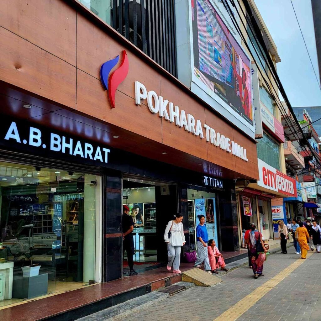The bustling pedestrian sidewalk and ground floor shops outside Pokhara Trade Mall